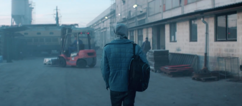 adolescent devant une usine