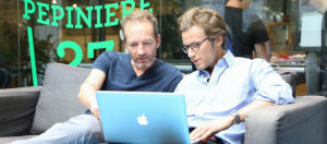 deux hommes travaillent sur un mac