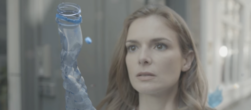 femme face à une bouteille plastique