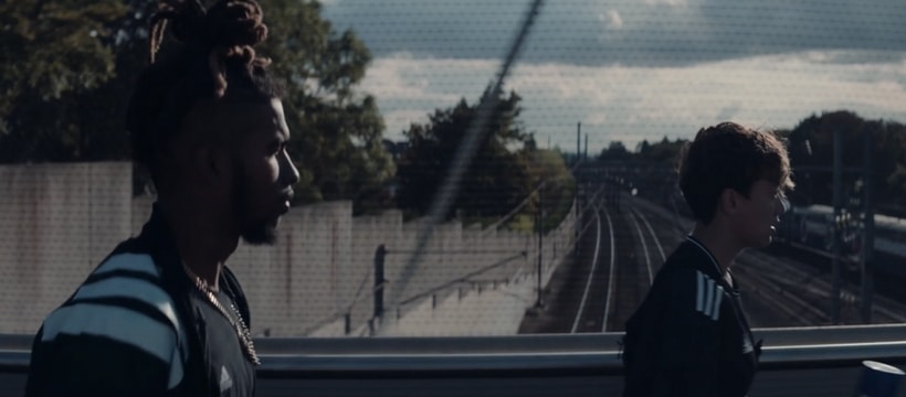 adidas hommes marchant sur un pont
