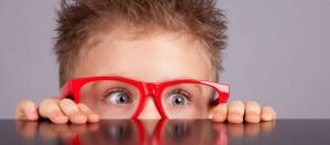 enfant a moitie cache derriere une table