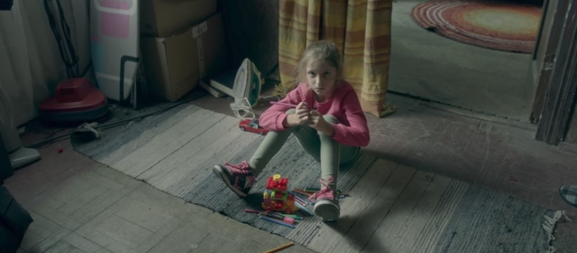 Croix Rouge enfant assise dans une maison insalubre
