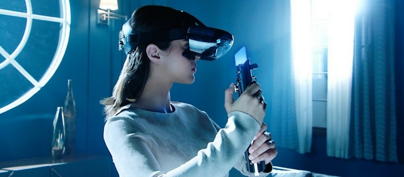 Star Wars Jedi Challenge femme avec un casque de realite augmentee et un sabre laser