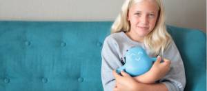 petite fille blonde assise sur un canapé bleu