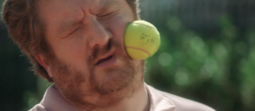 homme qui reçoit une balle de tennis sur le visage