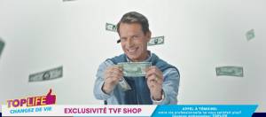 un homme qui tient un billet à la télévision
