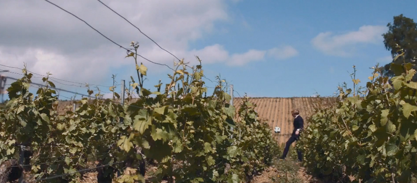 La stratégie social media de Taittinger pour la Coupe du Monde un homme en costume qui joue au foot dans les vignes