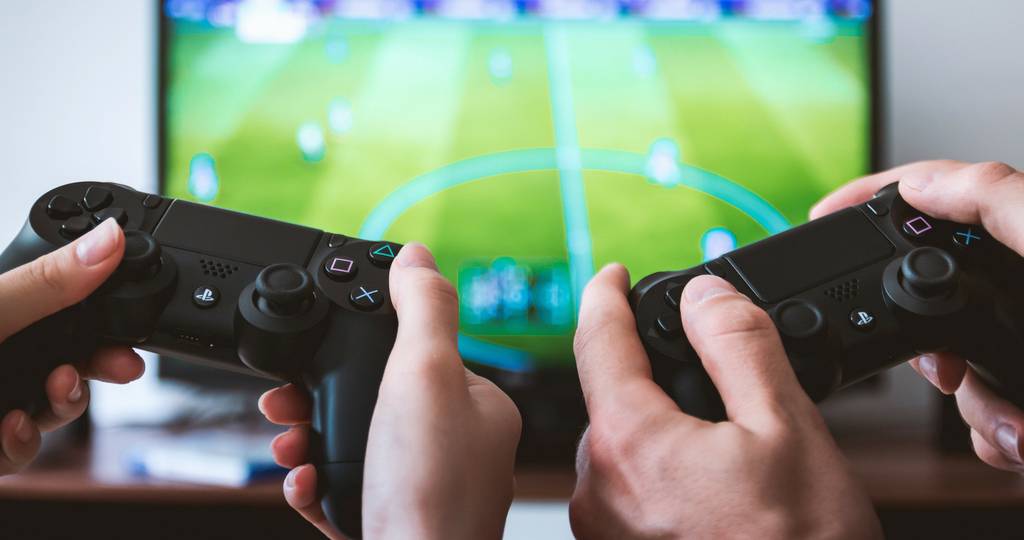 Esport : Millenium lance une gamme d'accessoires Deux manettes de console devant un jeu vidéo de football