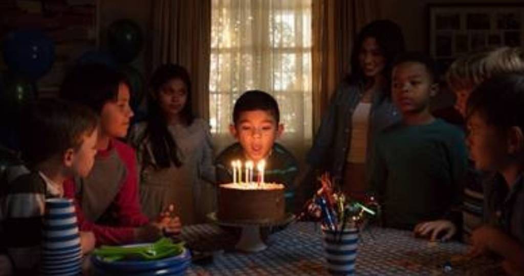 Un jeune garçon en train de souffler ses bougies d'anniversaire