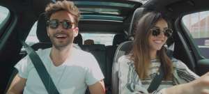 Un homme et une femme dans une voiture avec des lunettes de soleil