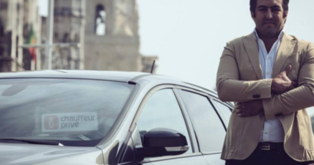 Un homme devant une voiture Chauffeur Privé