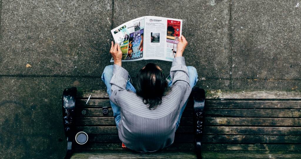 homme qui lit un journal papier