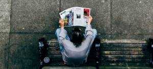 homme qui lit un journal papier