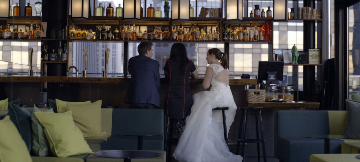 Booking lance le concours #bookinghero Une femme en robe de marié et un homme dans un bar