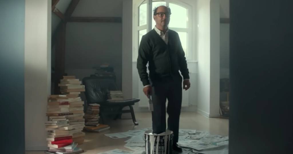 Un homme avec un pied dans un pot de peinture