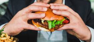 Un homme qui mange un burger en gros plan