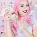 Une influenceuse avec des cheveux roses qui se filme une chaussure à la main