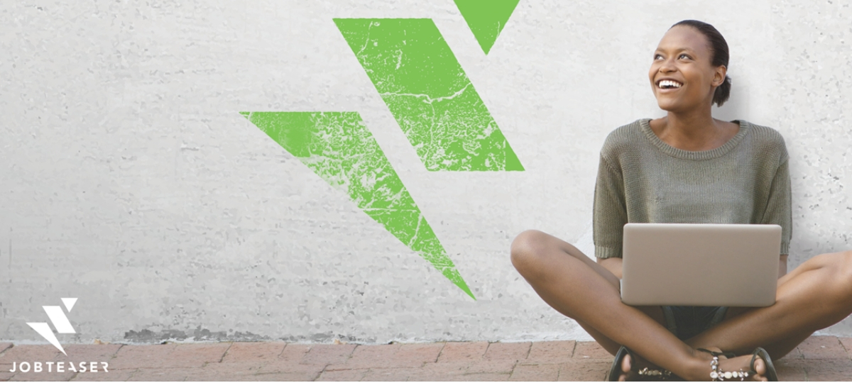 JobTeaser consolide sa position en Europe Une femme assise en tailleur en train de travailler sur son ordinateur portable
