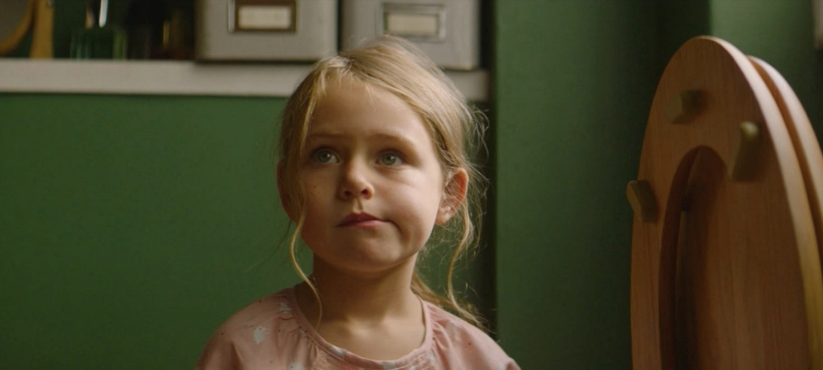 La publicité de Noel d'Auchan Une petit fille blonde qui réfléchit