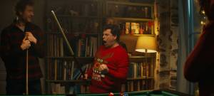 Un homme avec un pull de Noël qui fait du billard