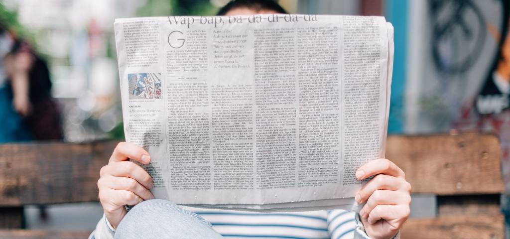 Un homme qui lit un journal papier