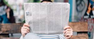 Un homme qui lit un journal papier