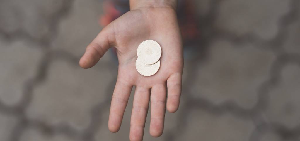 Une main tendue avec une pièce de monnaie