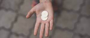 Une main tendue avec une pièce de monnaie
