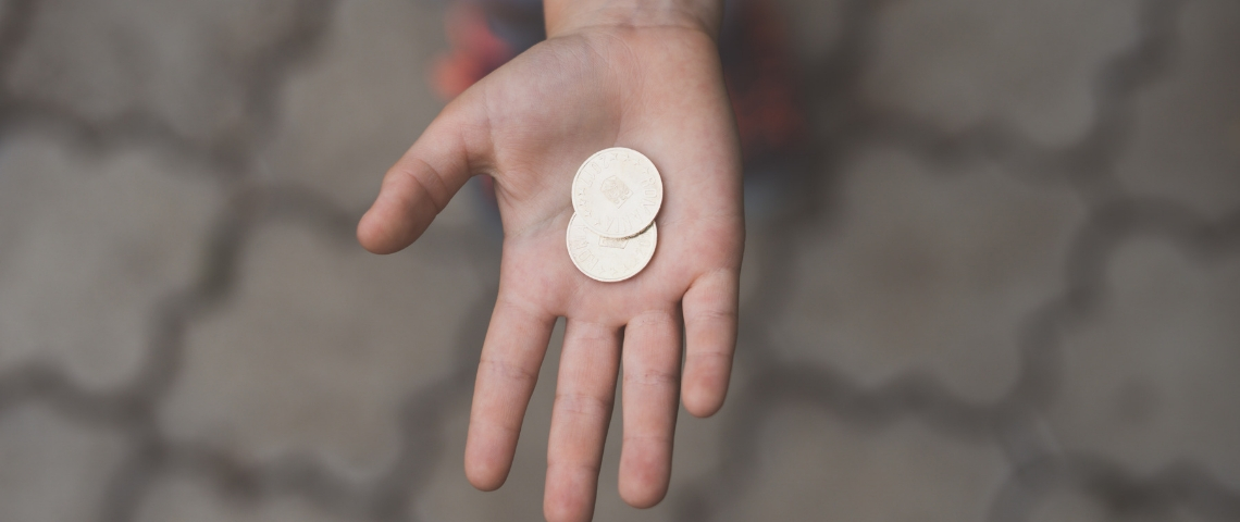 Une main tendue avec une pièce de monnaie