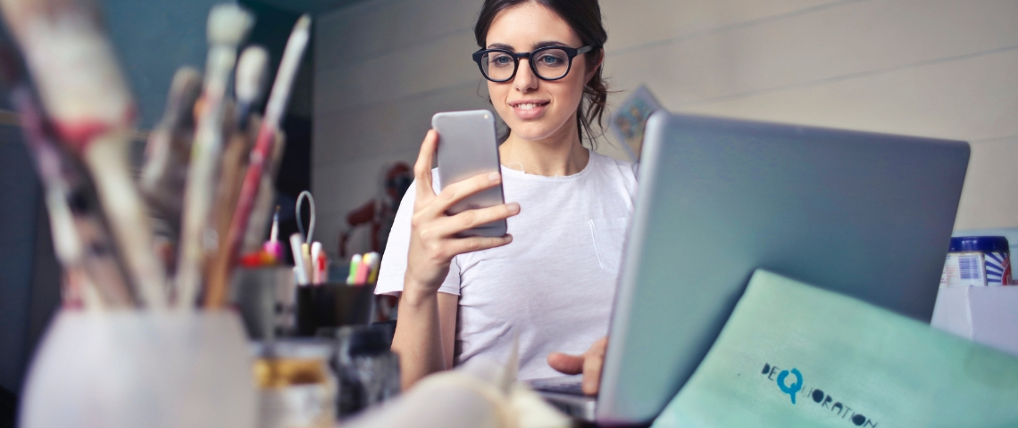 Une nouvelle plateforme pour soutenir les start-up media Une femme avec son smartphone devant son ordinateur