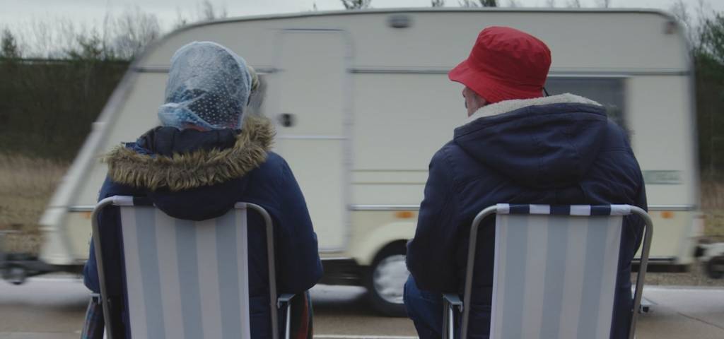 Deux personnes qui regardent une caravane passer