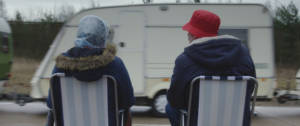 Deux personnes qui regardent une caravane passer
