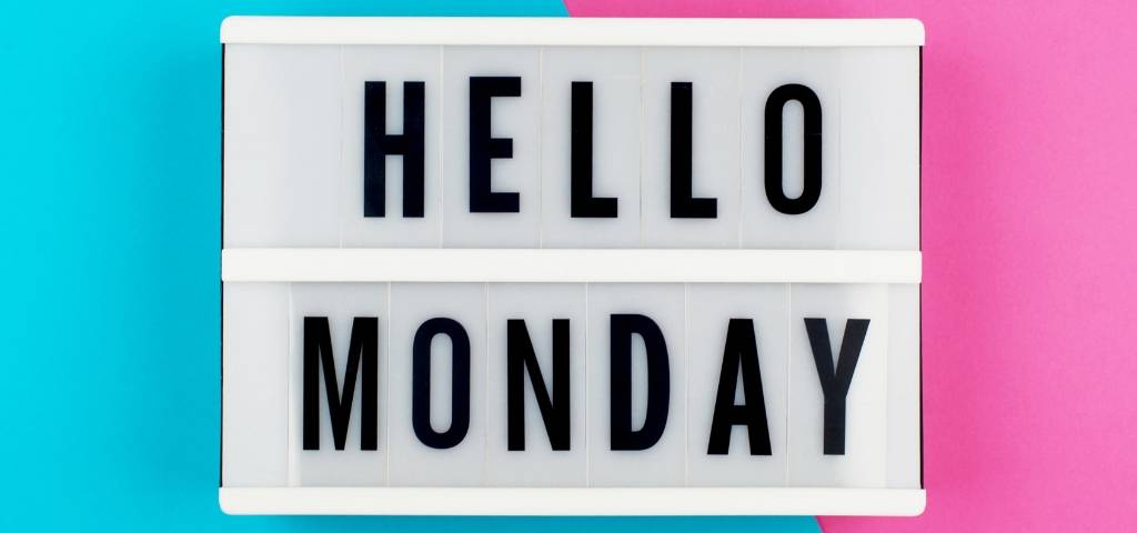 Un panneau  - Hello Monday -  sur fond rose et bleu