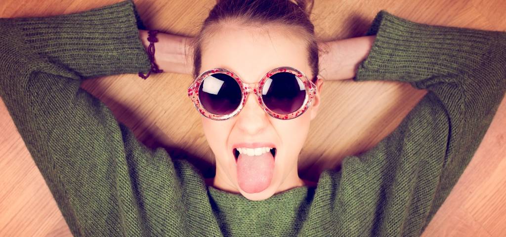 Une femme avec des lunettes de soleil qui tire la langue