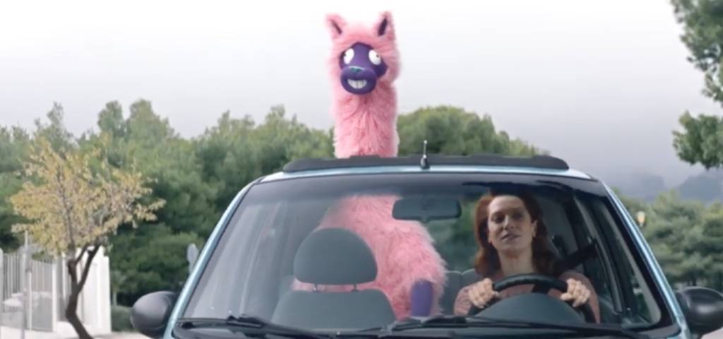 Une femme au volant d'une voiture avec un lama rose