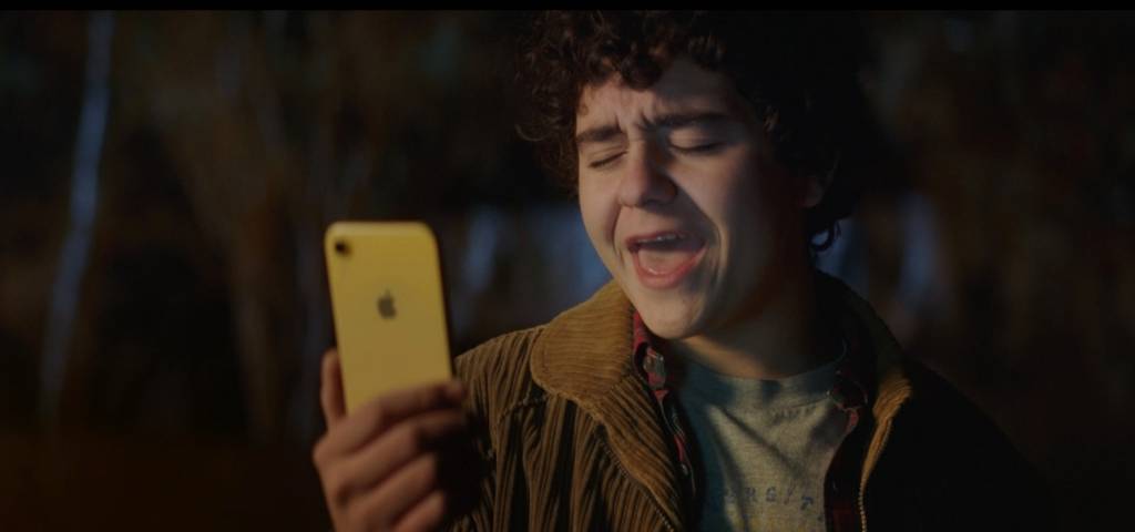Un garçon qui chante face à son iPhone