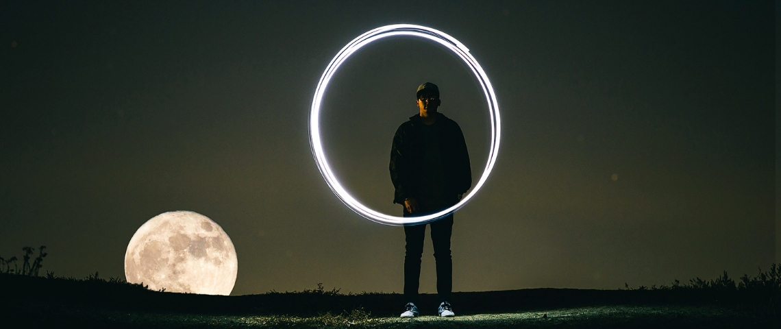 Comment atteindre la position zéro sur Google ? Un homme, la lune et un cercle lumineux