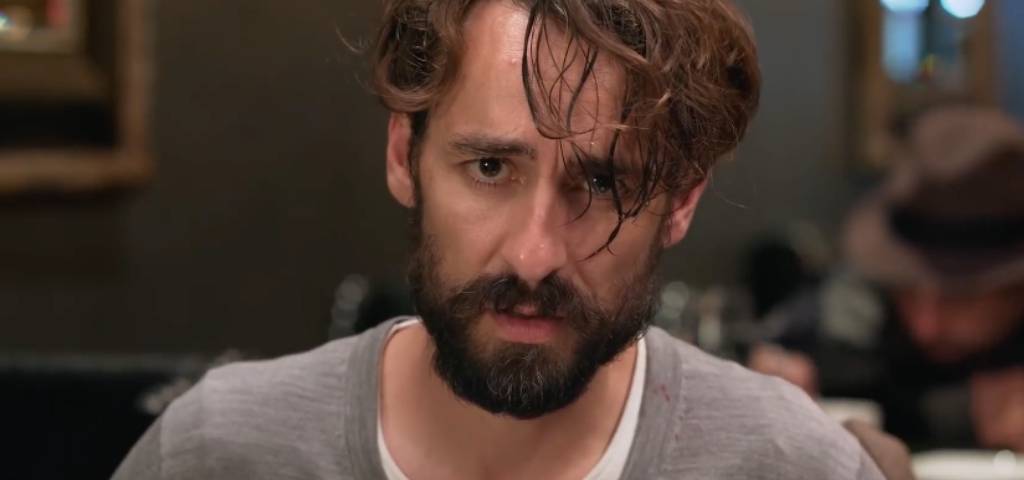 Un homme avec une barba qui regarde la caméra