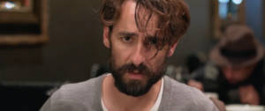 Un homme avec une barba qui regarde la caméra