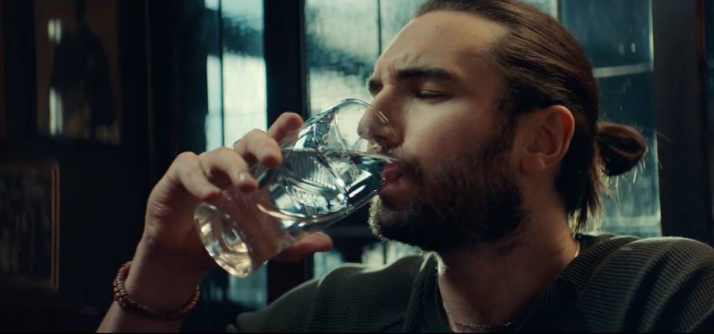 Une homme qui boit de l'eau dans une pinte de Guinness