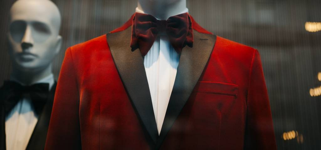Un mannequin vêtu d'un costume rouge et d'un noeud papillon