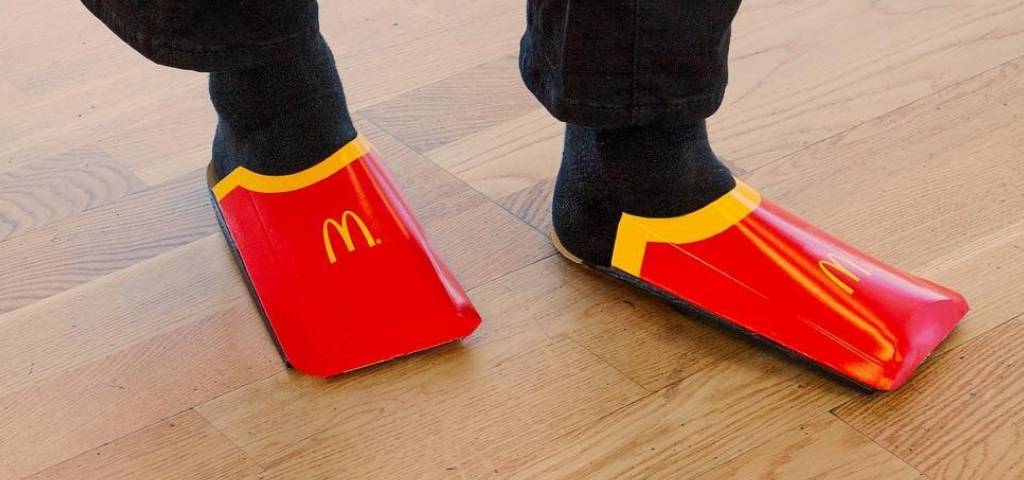 Des pieds avec des emballages de frites McDonald's en guise de chaussures