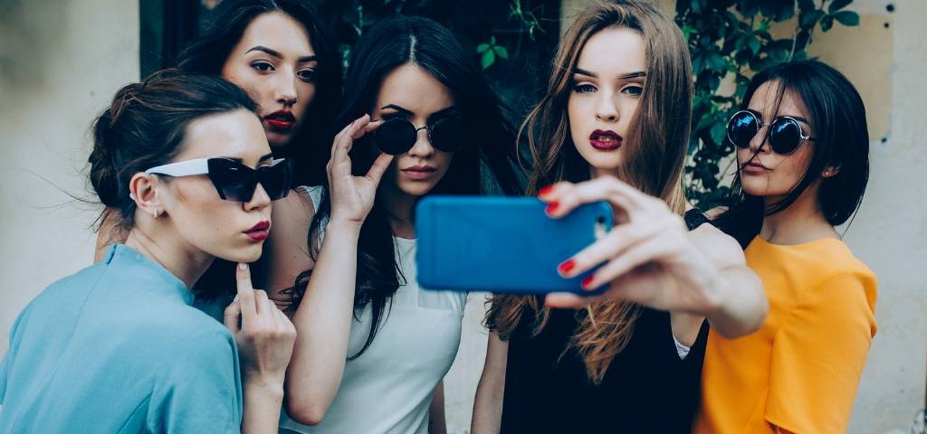 Comment bien utiliser le format Stories Des femmes en train de prendre un selfie