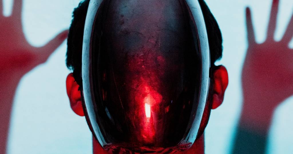 Un homme avec un masque noir et une lumière rouge sur la tête