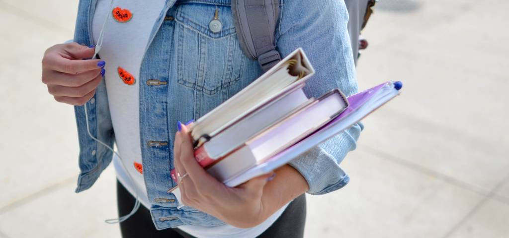 Une étudiante qui porte ses livres de classe