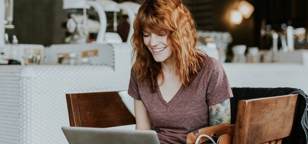 Une femme rousse qui travaille dans un café