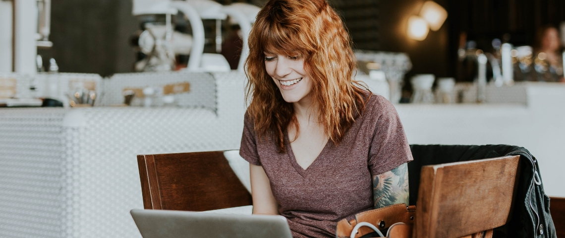 Le top 6 des hôtels où faire du coworking Une femme rousse qui travaille dans un café