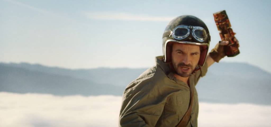 Decathlon parodie la télé Un homme habillé en aventurier avec un totem dans la main