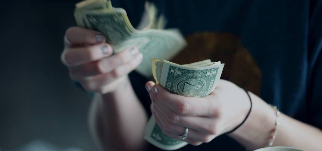 Une femme qui compte des billets de dollars