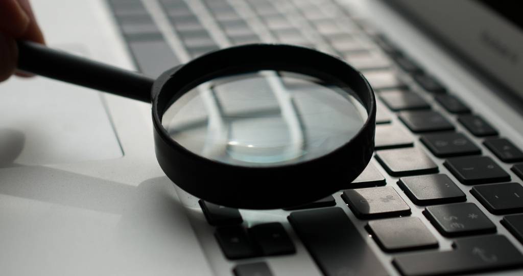Une loupe au-dessus d'un clavier d'ordinateur